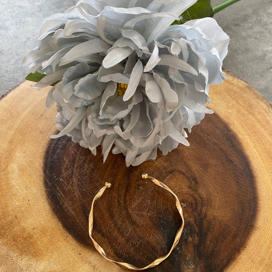 Gold coloured twisted bangle